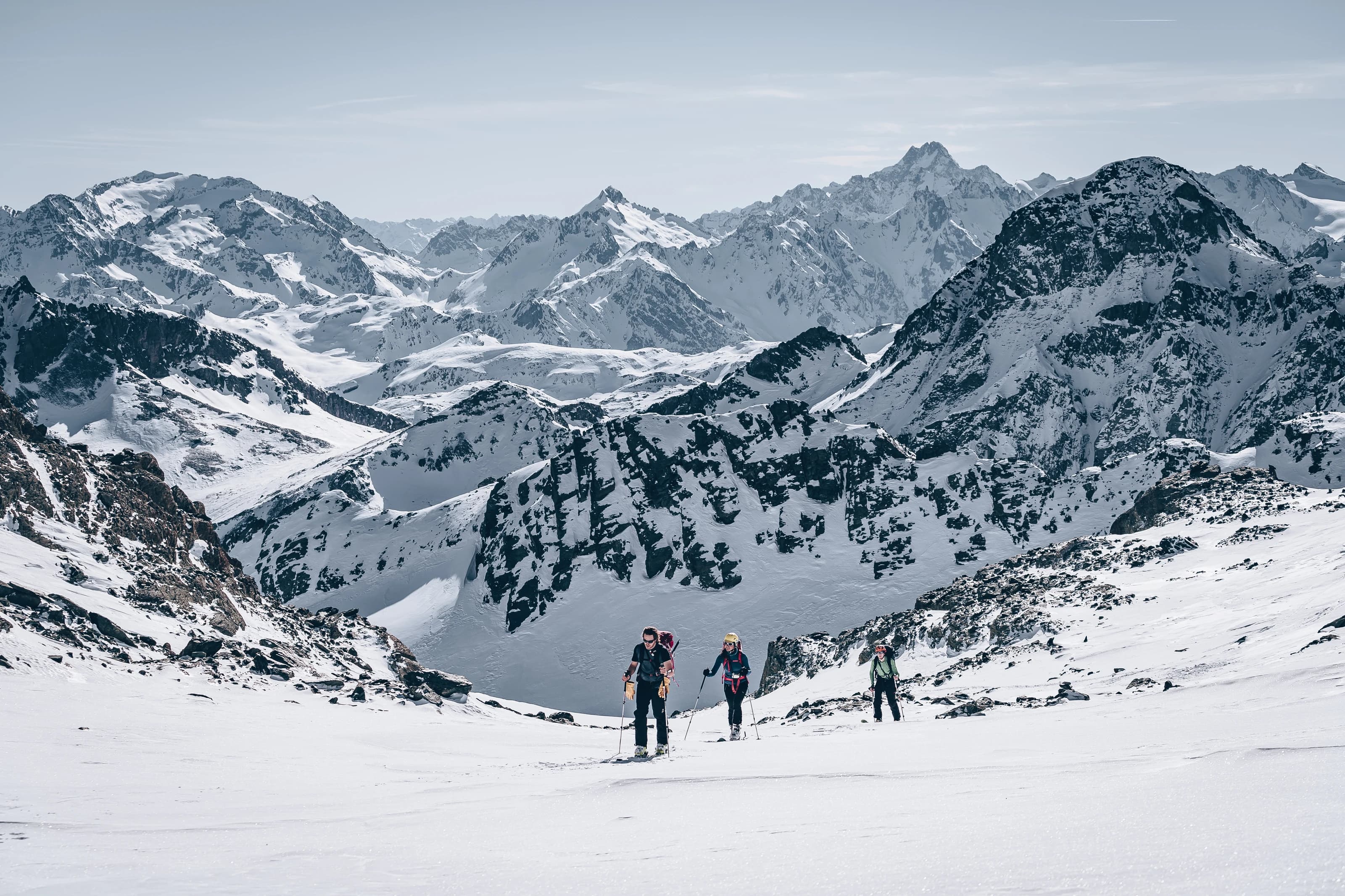 Wide-angle black-and-white photograph of a group of hikers reaching an alpine summit